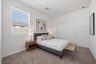bedroom with a spacious bed, with a grey bedframe, walnut nightstands, and beige bed bench
