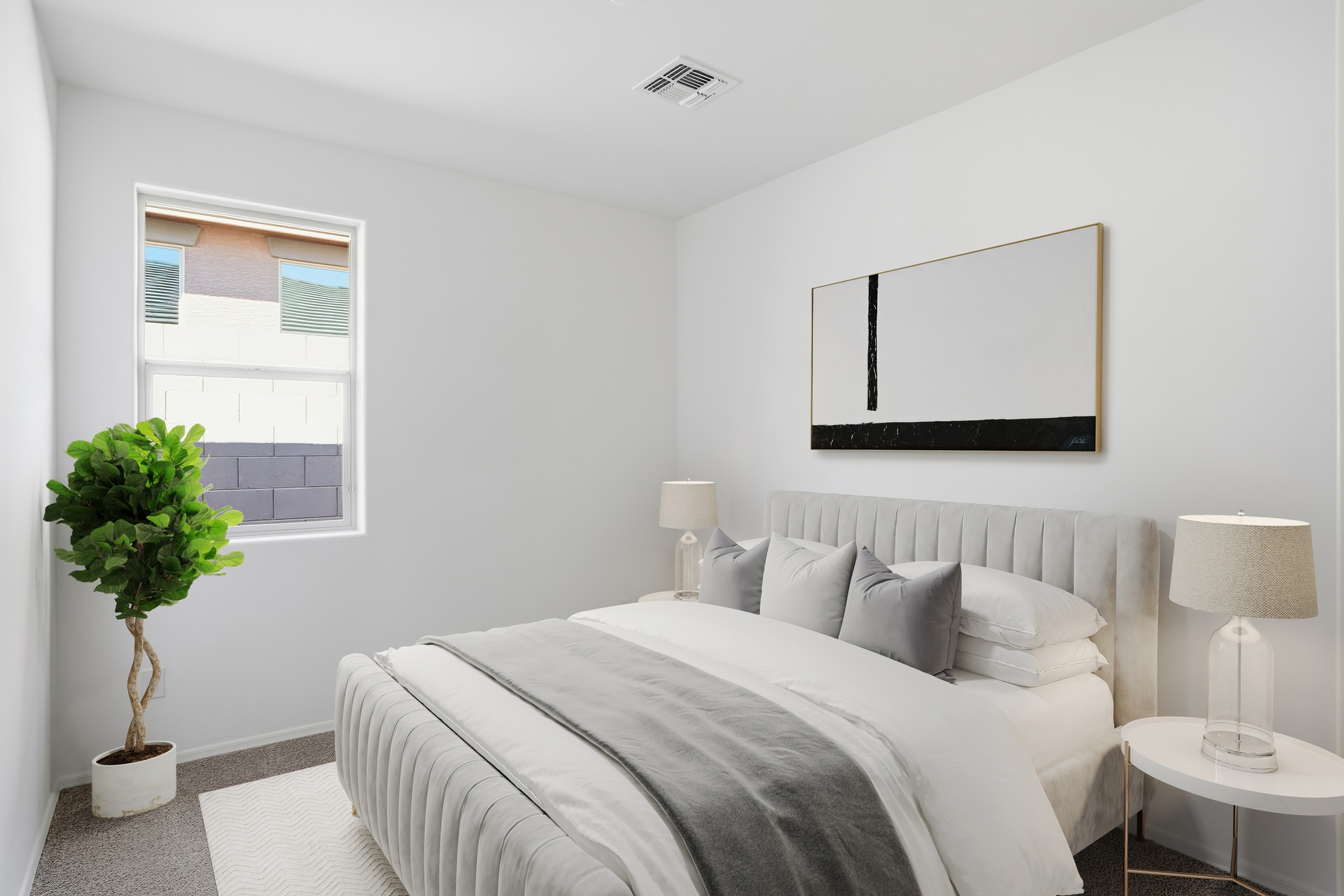 bedroom with a large white bed with a grey duvet, and an indoor plant