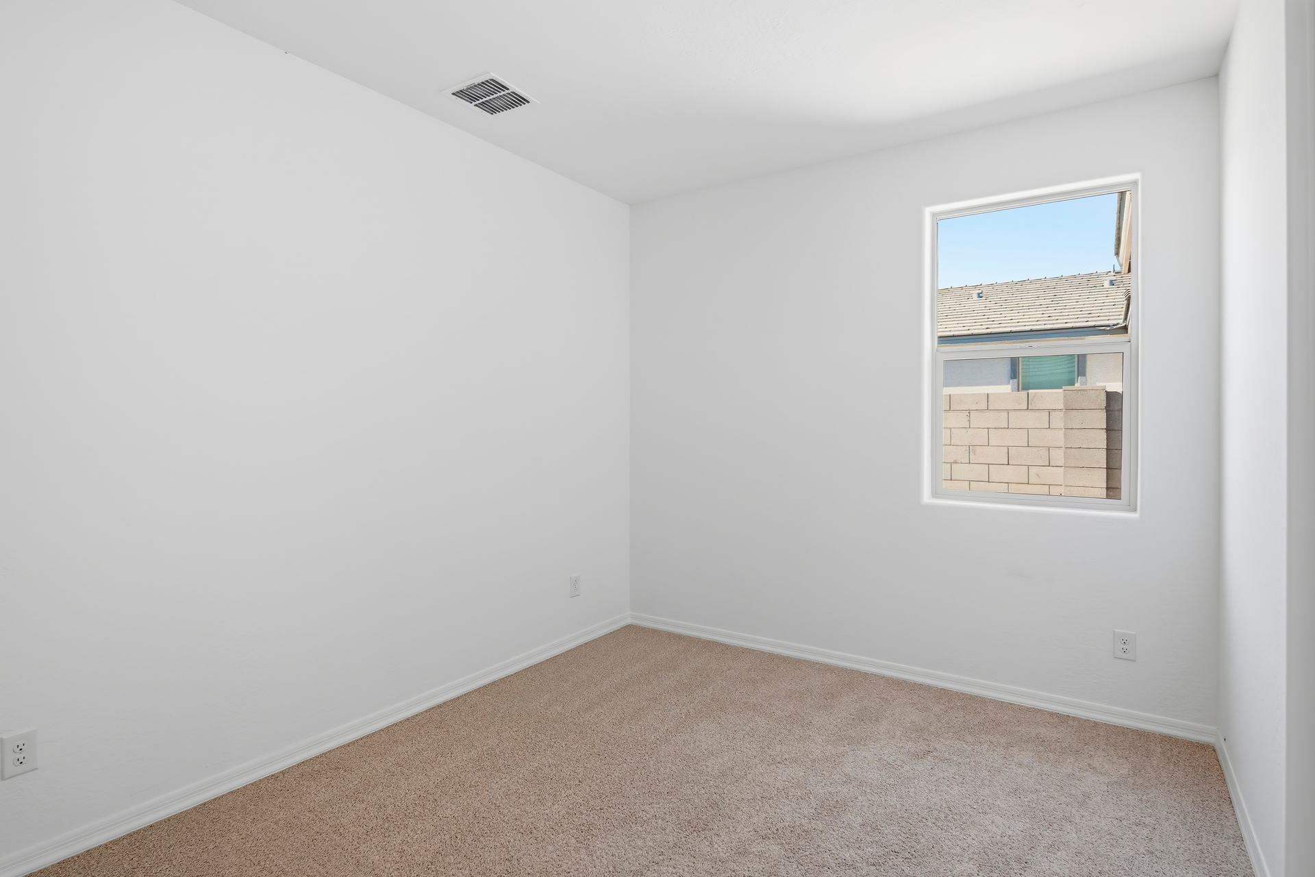 spacious bedroom with light brown carpet and closet with sliding door