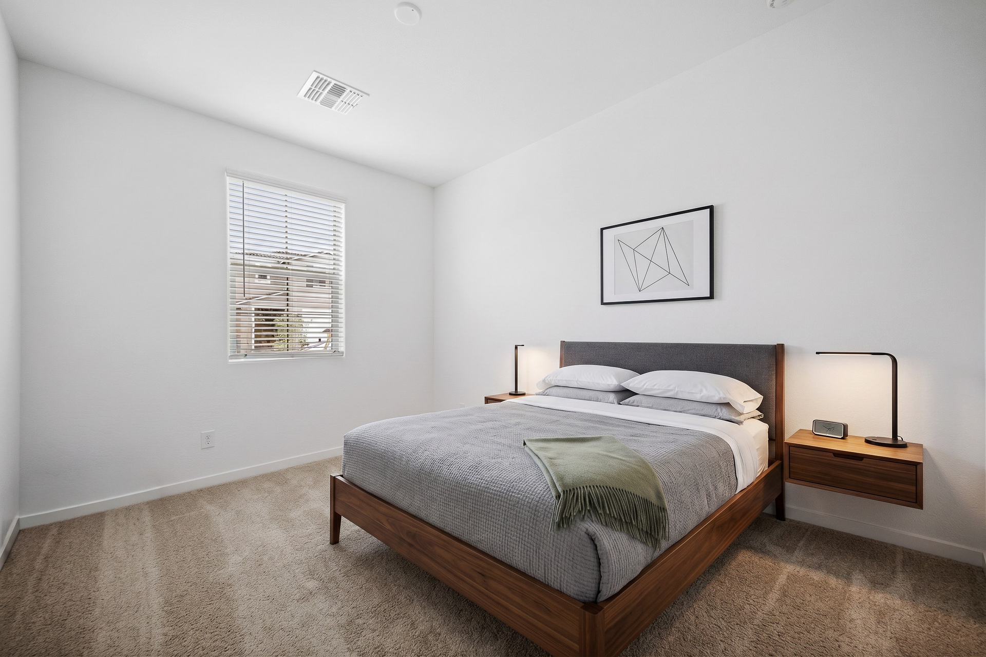 spacious bathroom with walnut bedframe, floating walnut nightstands, and grey duvet cover