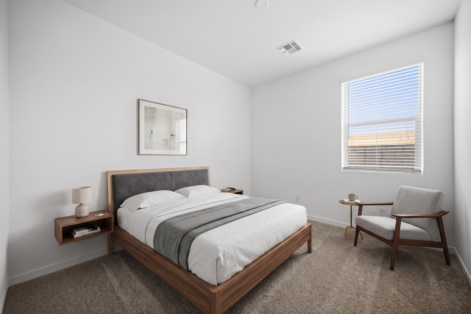 bedroom with a large walnut bedframe, floating walnut nightstands, and a grey accent chair