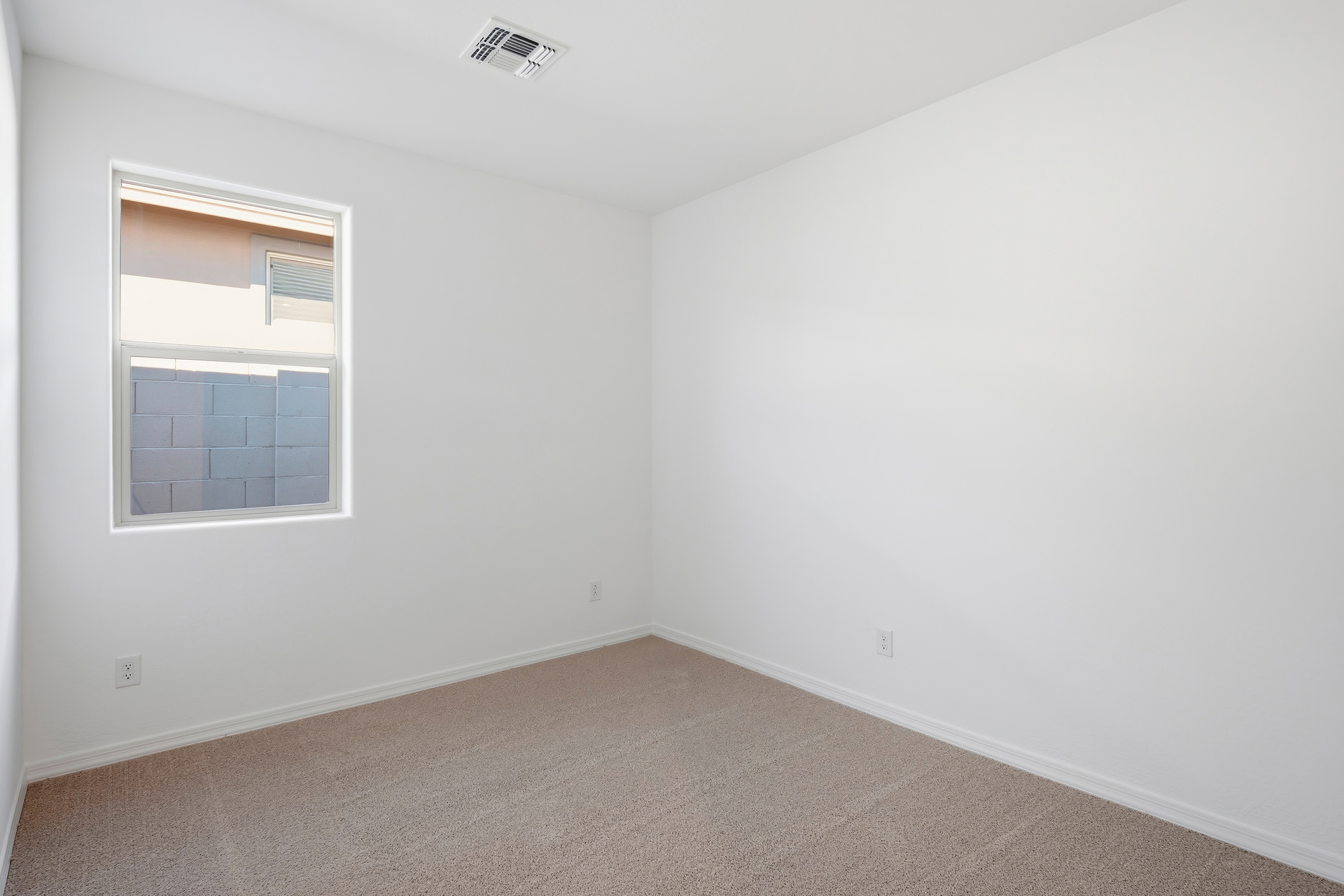 bedroom with light brown carpet and window for natural light