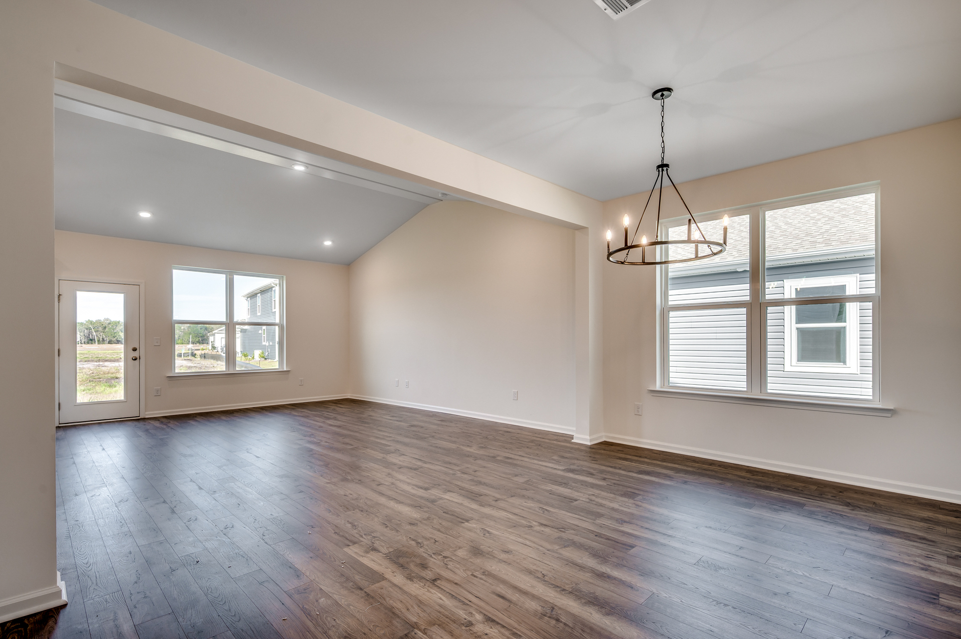 open-concept area with tan walls and hardwood flooring throughout
