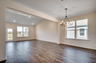 open-concept area with tan walls and hardwood flooring throughout
