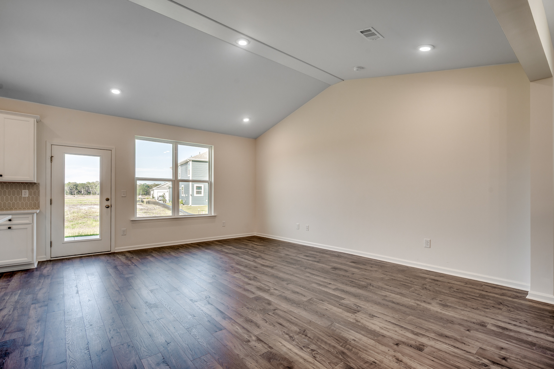 large windows for natural lighting, high ceilings with puck lighting and hardwood floors throughout