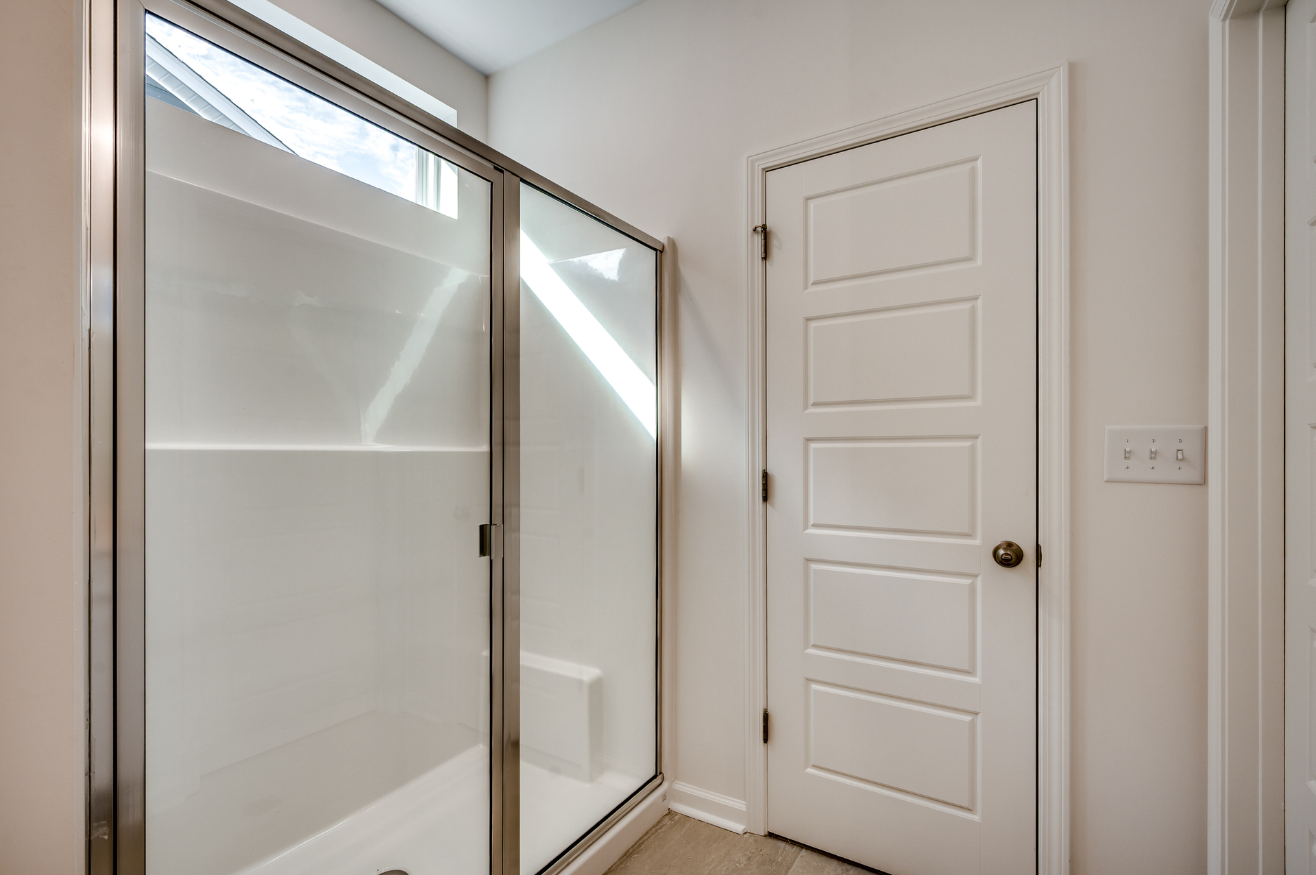 bright white spacious walk-in shower with tile flooring