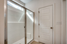 bright white spacious walk-in shower with tile flooring