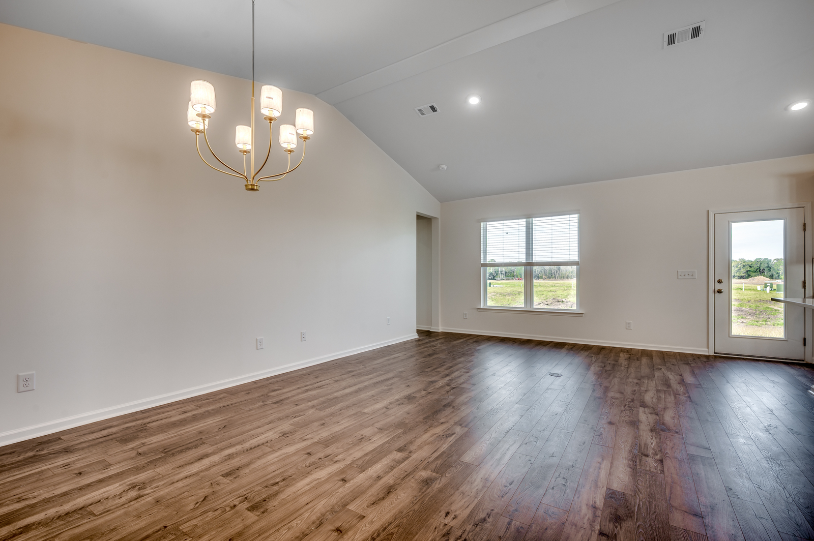 open-concept room with high ceilings, puck lighting and hardwood flooring throughout