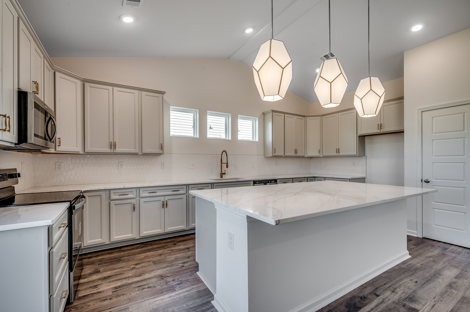 light gray cabinets with white tile backsplash and white quartz countertops