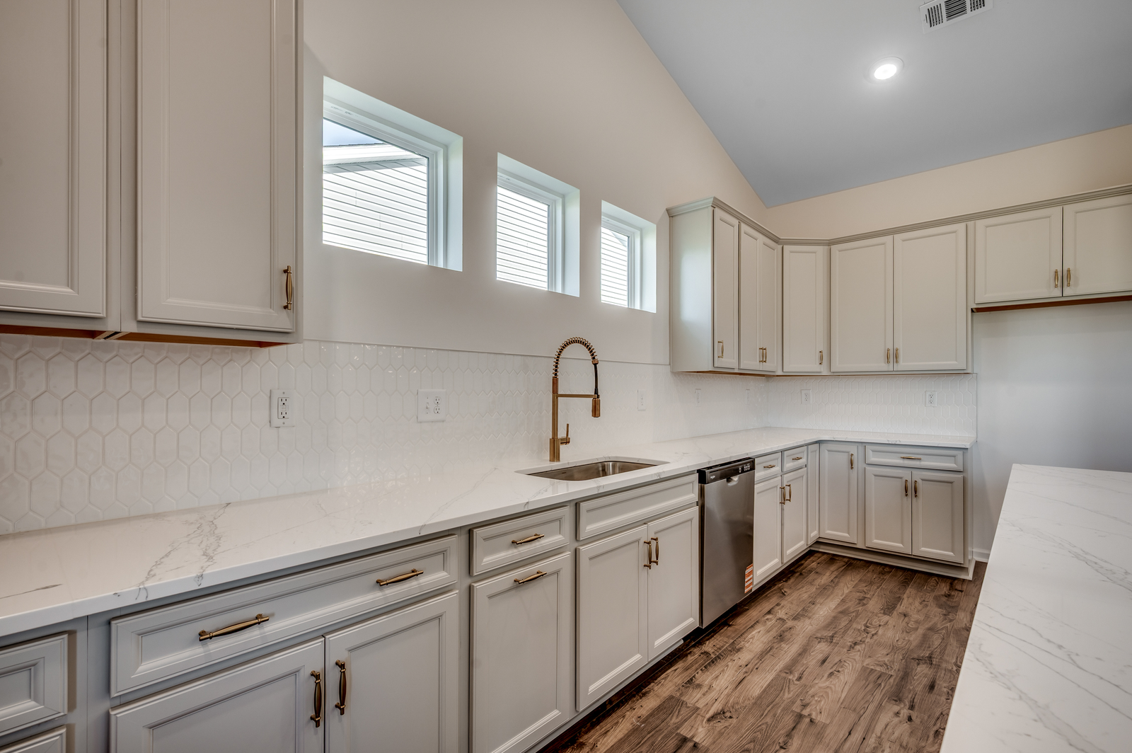 light gray cabinets with gold hardware and quartz countertops throughout
