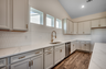 light gray cabinets with gold hardware and quartz countertops throughout 
