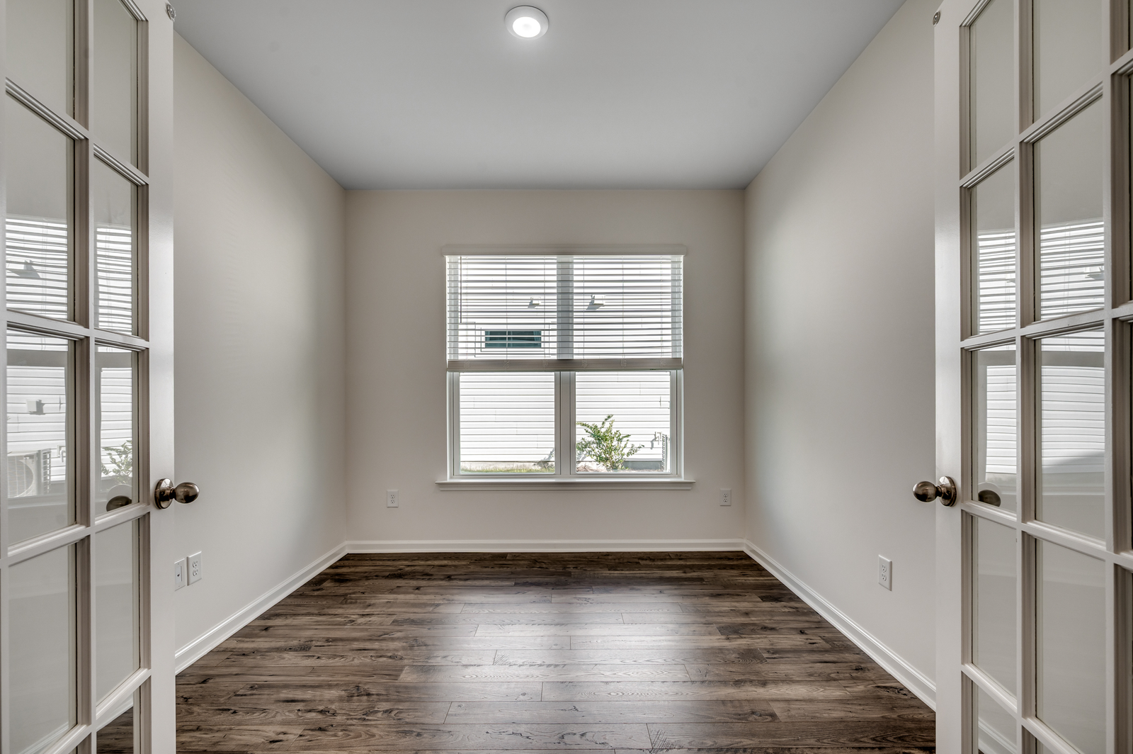 large windows for natural light, hardwood flooring and glass french doors