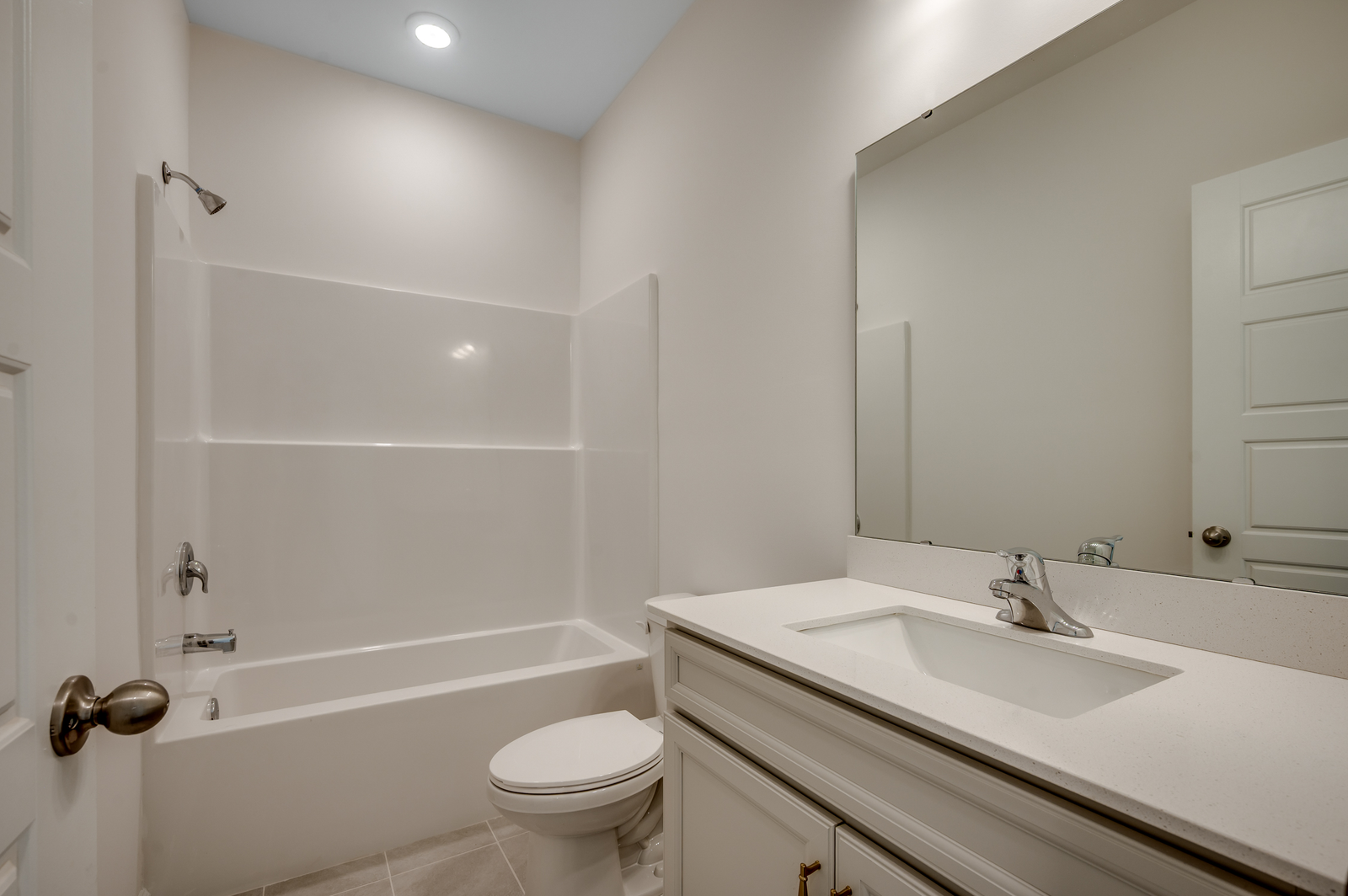 light gray cabinets with bright white quartz countertops and spacious shower