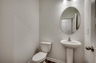tan walls, large mirror and single sink vanity 