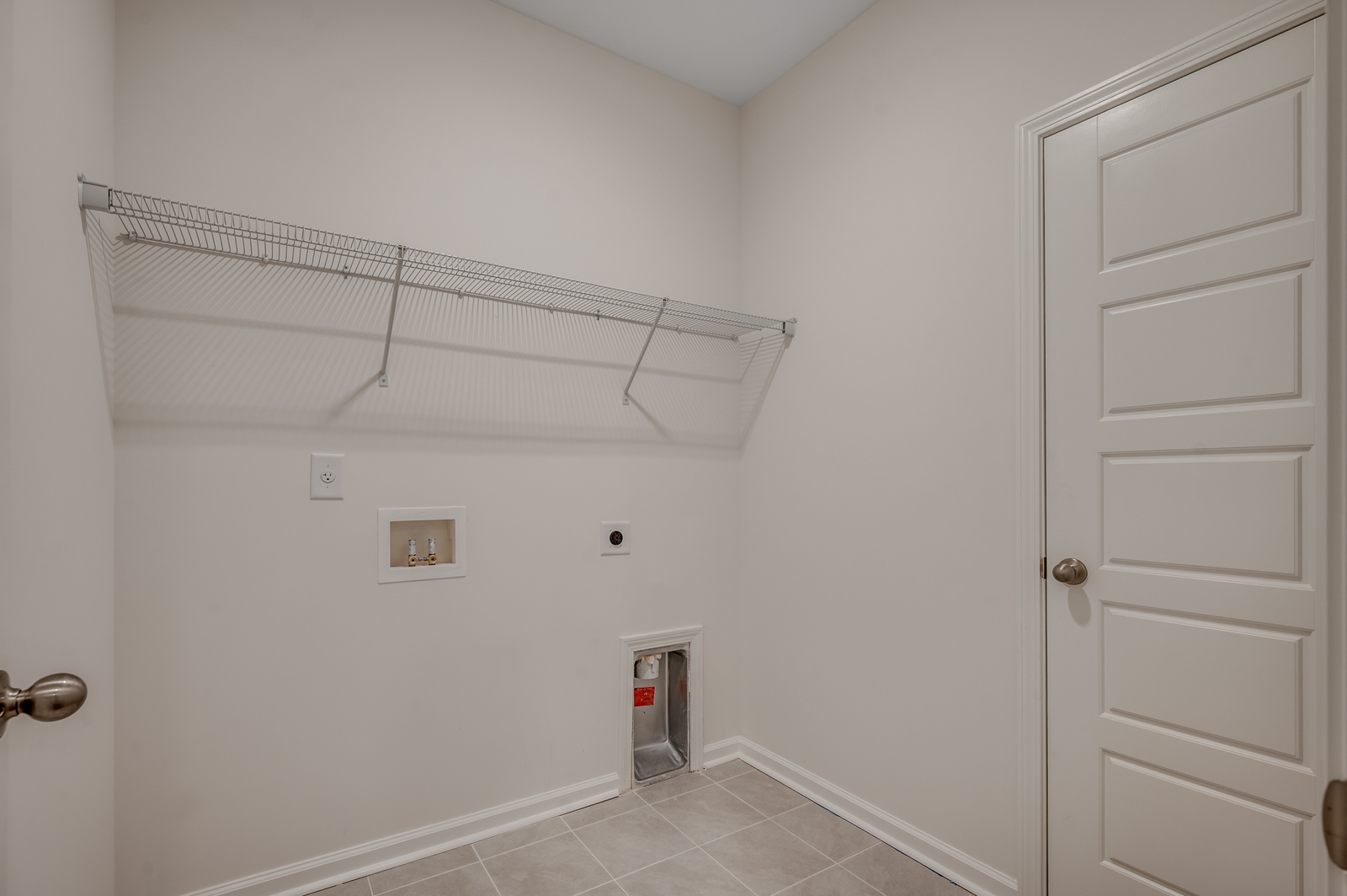 spacious room with tan walls, white wire built in shelving and tile flooring