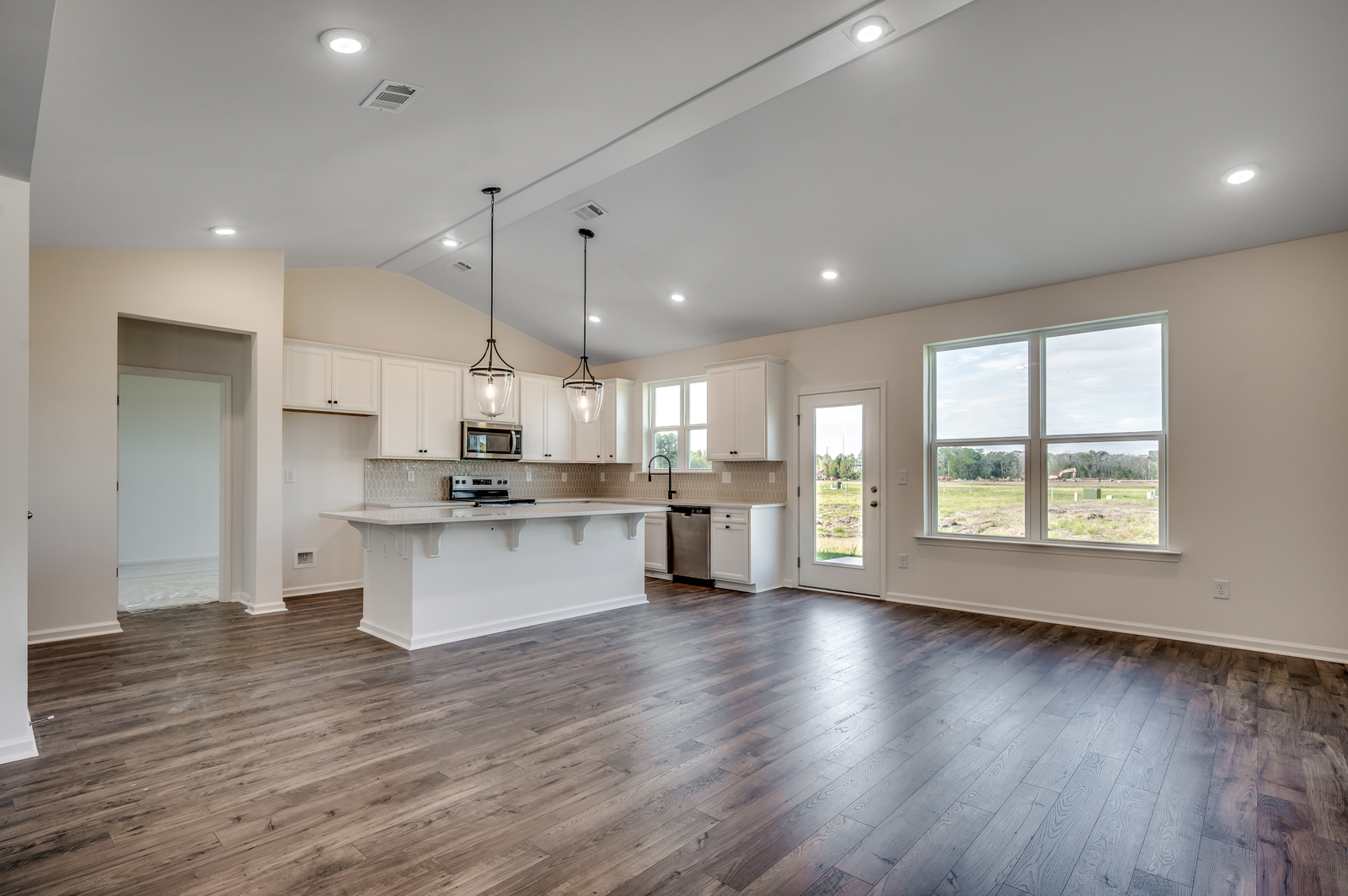 open-concept room with high ceilings and puck lighting throughout
