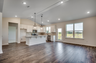 open-concept room with high ceilings and puck lighting throughout 