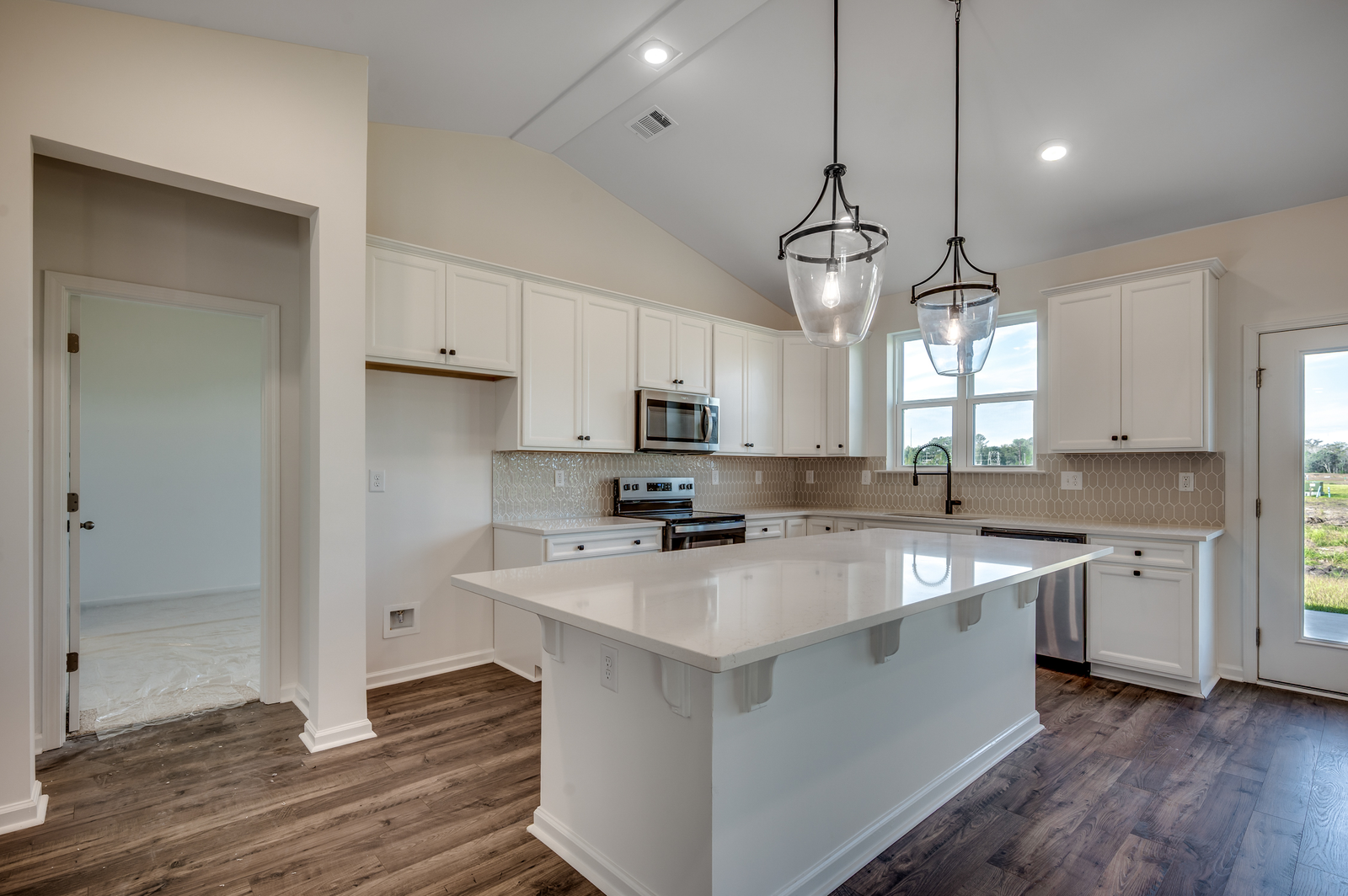 open-concept island with white quartz countertops and stainless steel appliances