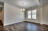 spacious room with large chandelier and hardwood flooring throughout 