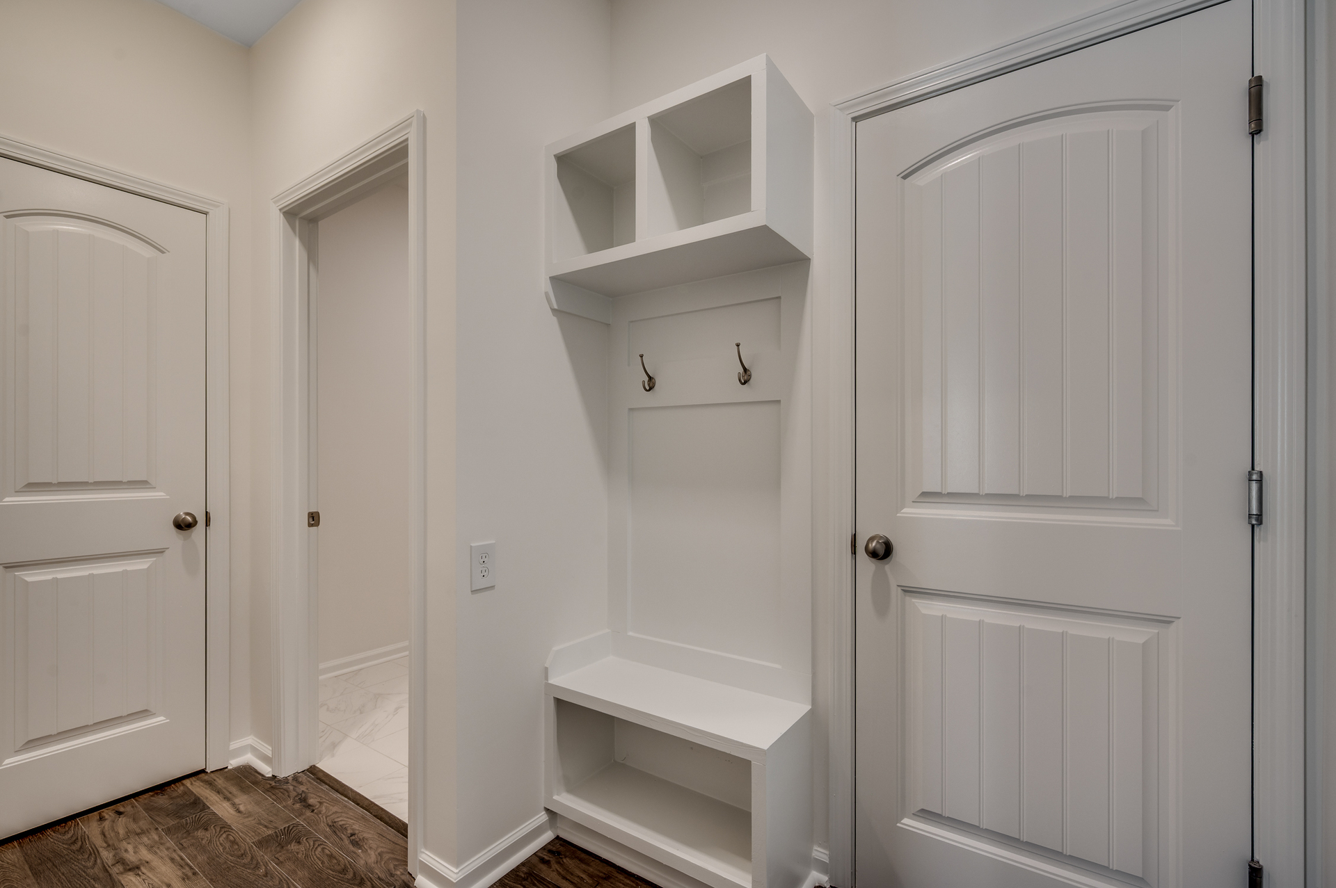 bright white built in shelving with bench for storage