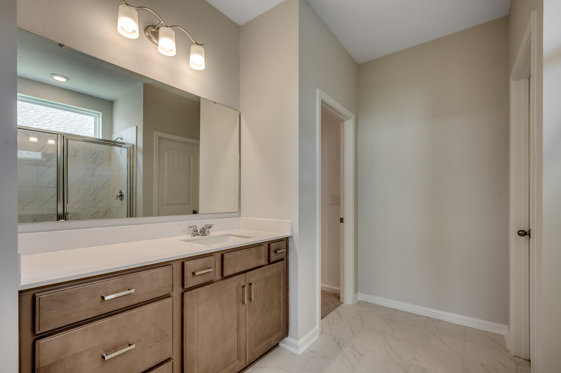 dark brown single sink vanity with walk-in shower and tile flooring