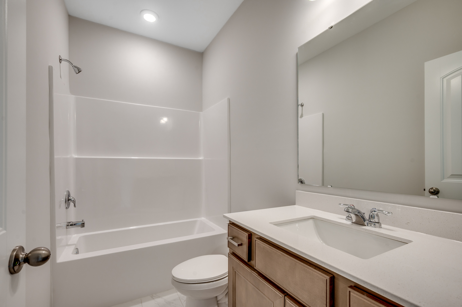 dark brown single sink vanity with large mirror and bright white shower