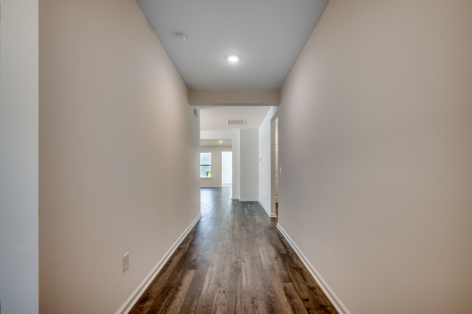 bright walls and ceiling with puck lighting and hardwood flooring
