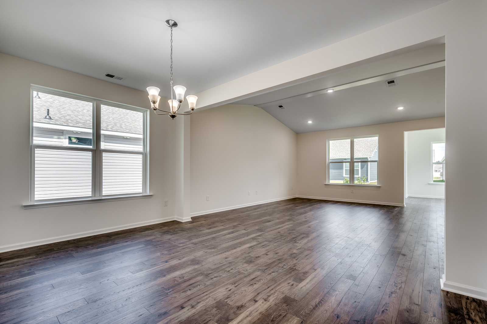 open-concept room with tan walls and hardwood flooring throughout