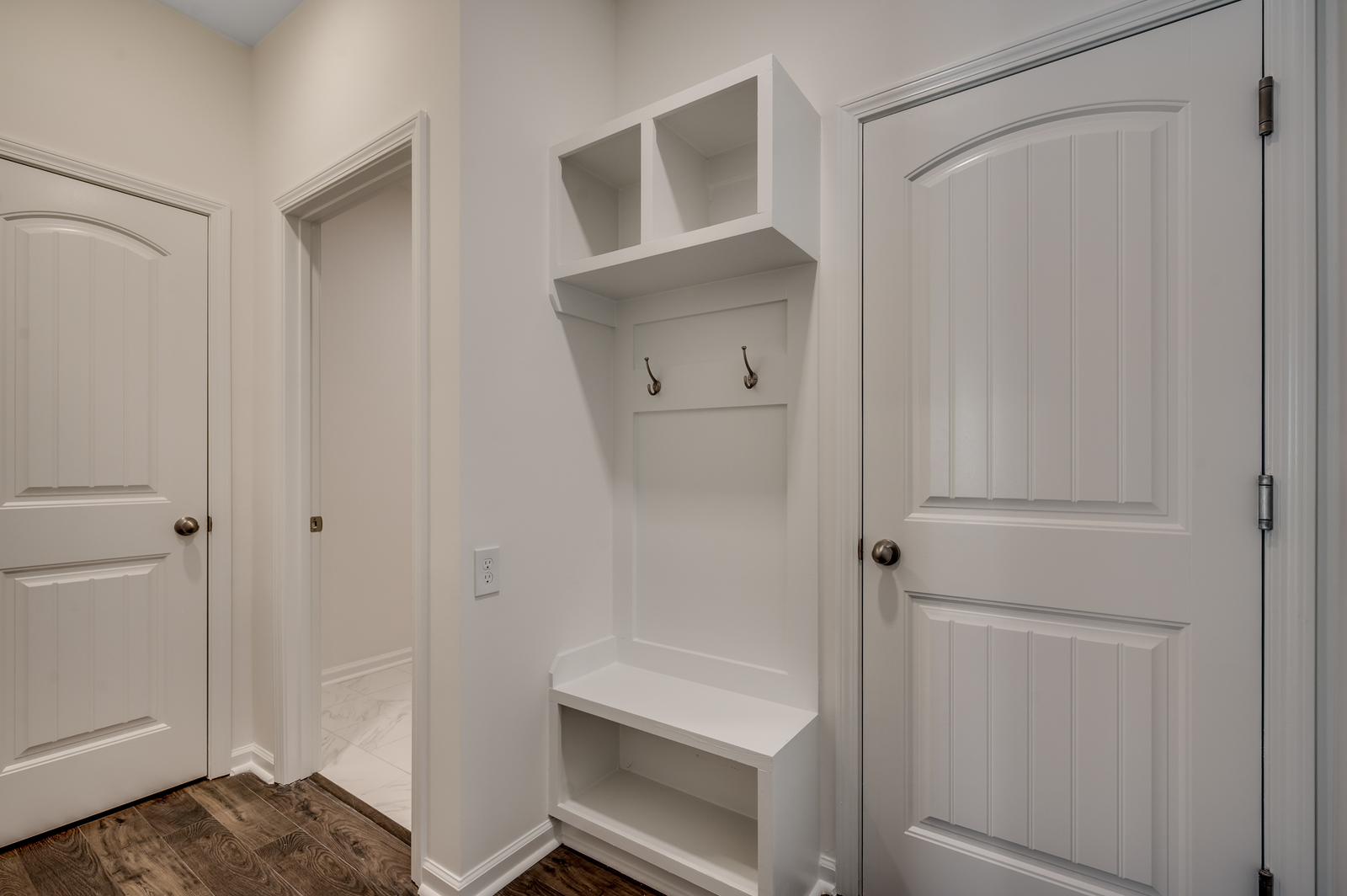 bright white built in shelving with bench for storage