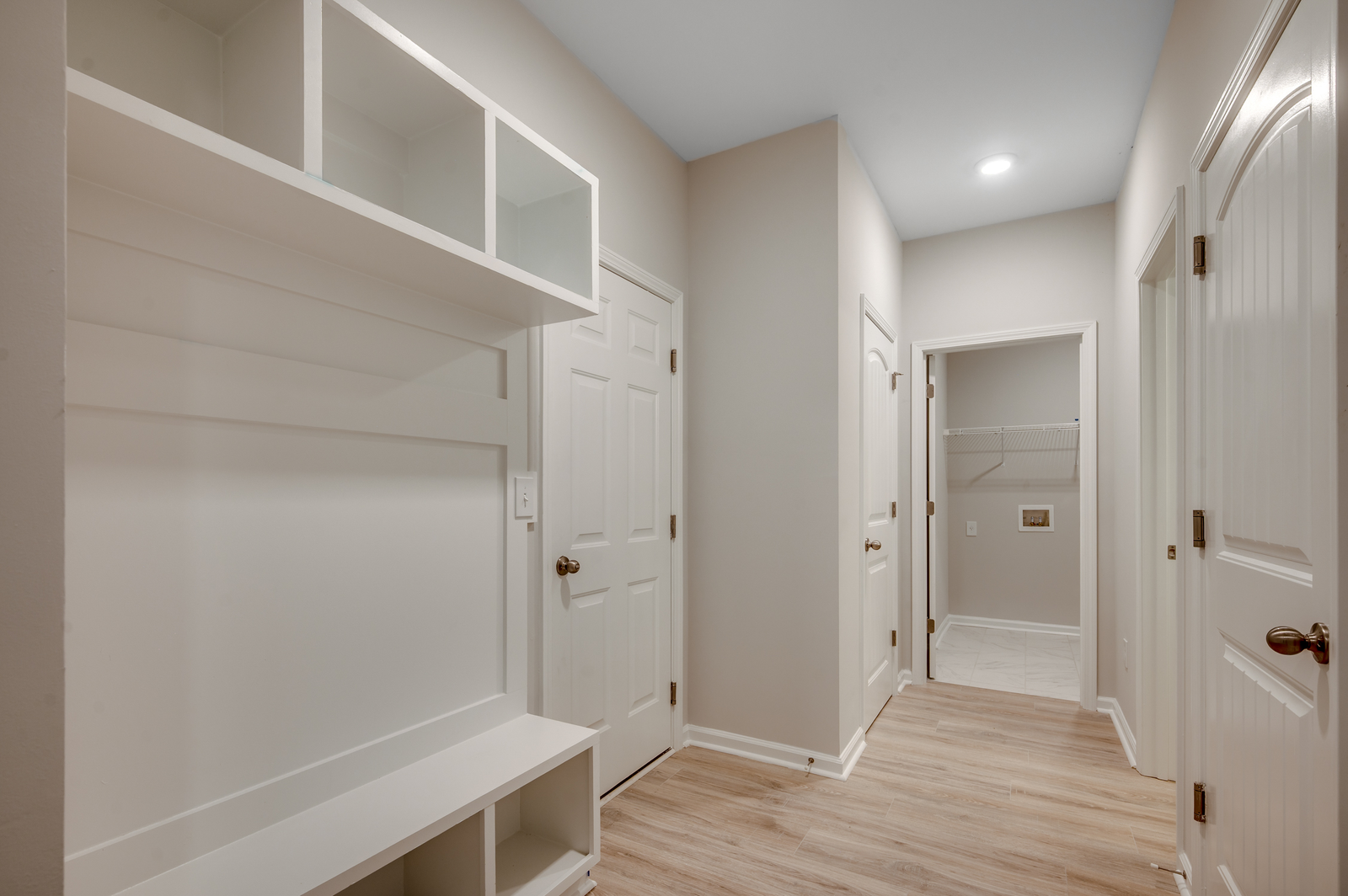 bright white built in shelving with bench for storage