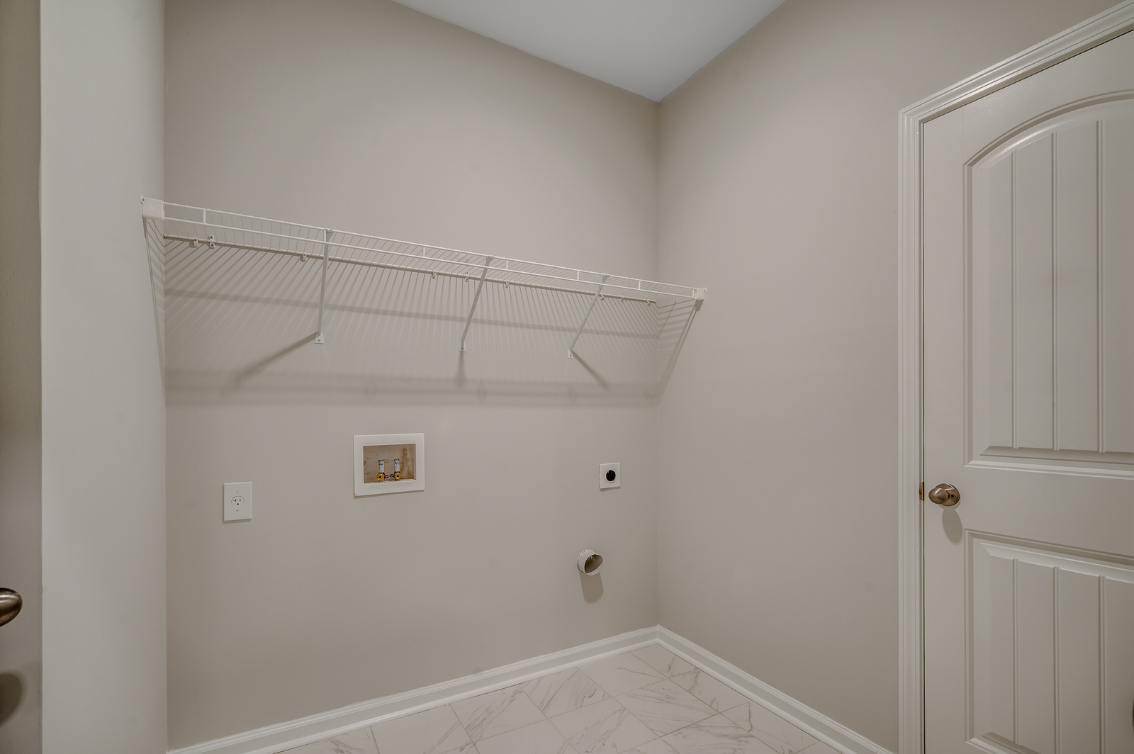 spacious room with tile flooring throughout, white wire shelving and tan walls
