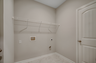 spacious room with tile flooring throughout, white wire shelving and tan walls