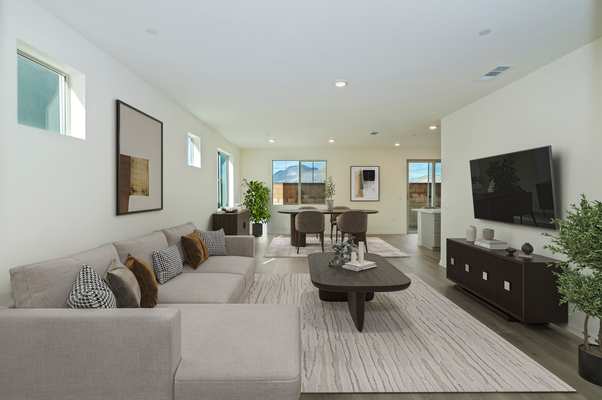 white couch with an oval coffee table and a tv mounted on the wall