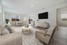 great room with neutral floors near dining area and kitchen