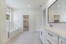 primary bathroom with neutral floors and white countertops