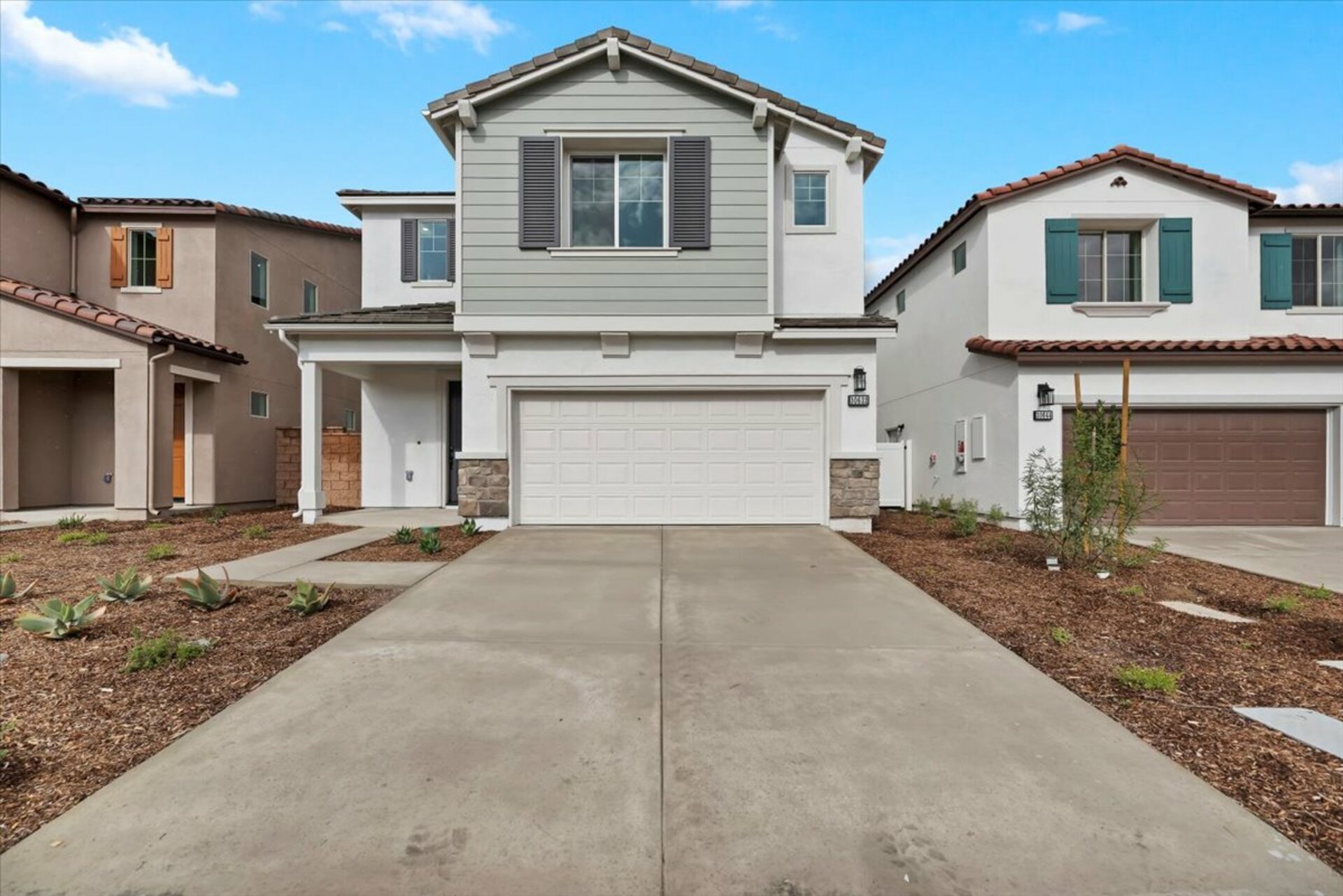 exterior of two-story home with desert landscaping and neutral paint