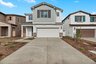 exterior of two-story home with desert landscaping and neutral paint