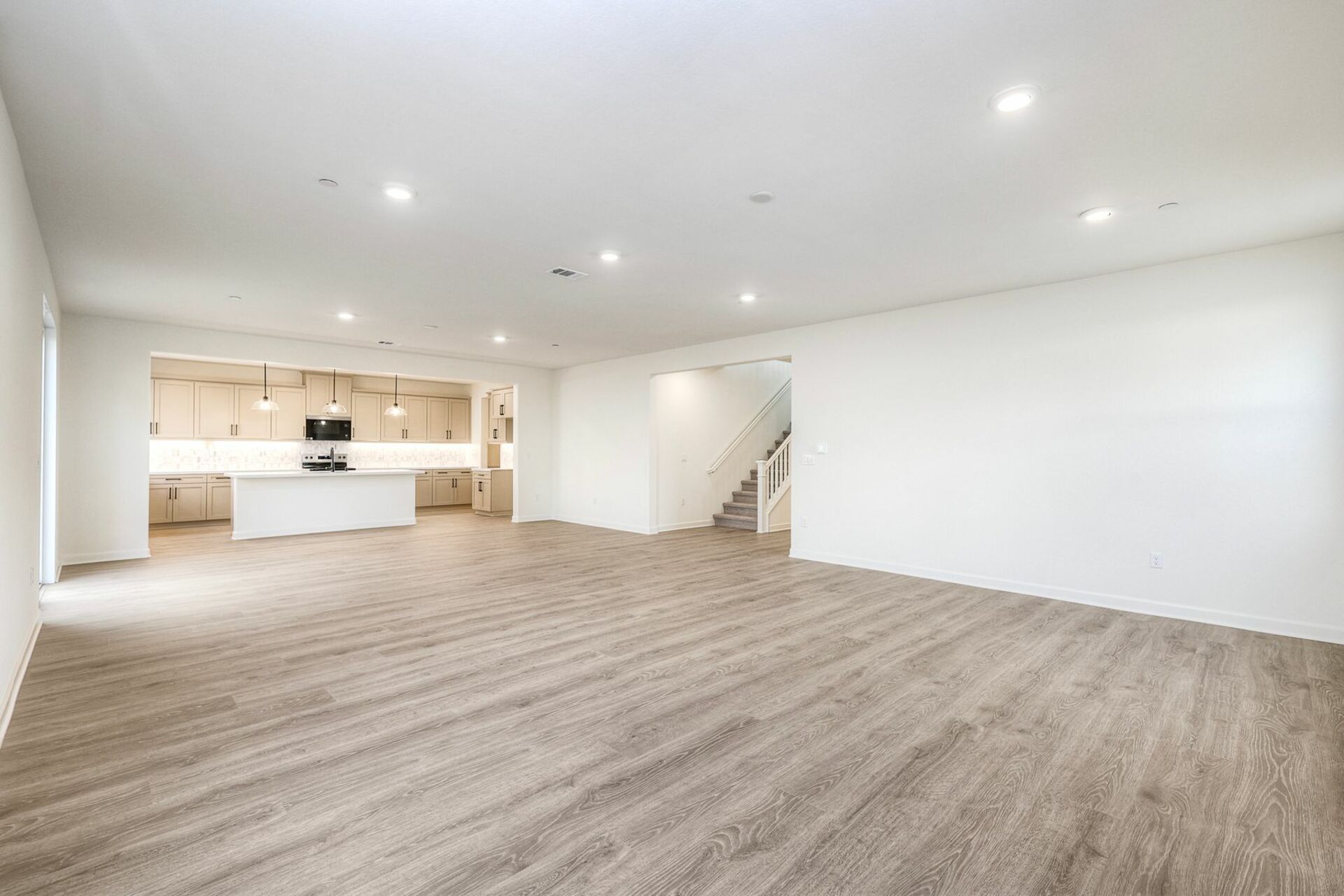 great room with wood-like flooring featuring the kitchen