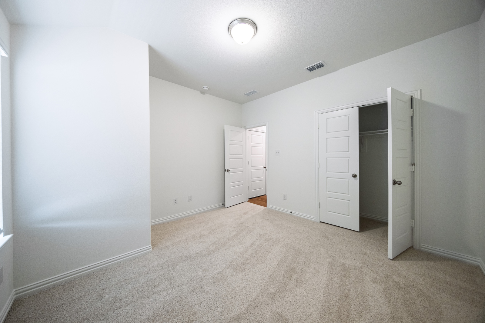 guest bedroom with carpet and window