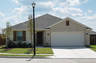 exterior of home with tan brick and brown window shutters