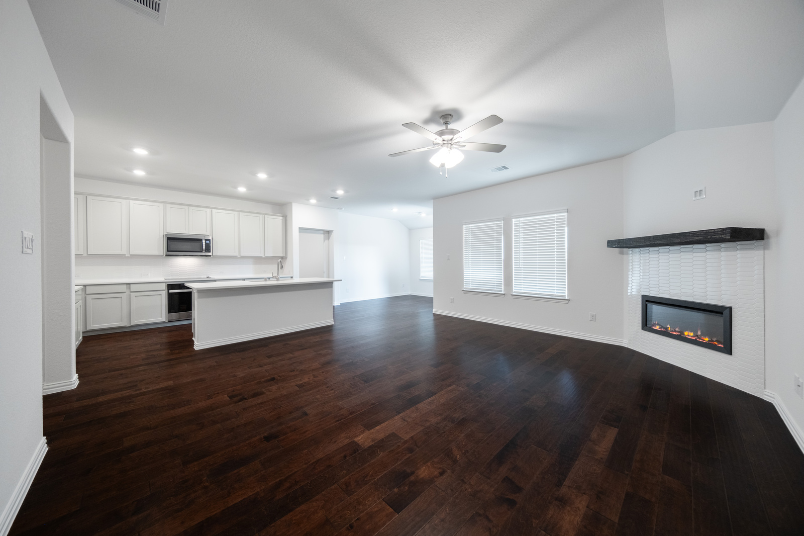 open great room with electric fireplace and hardwood flooring