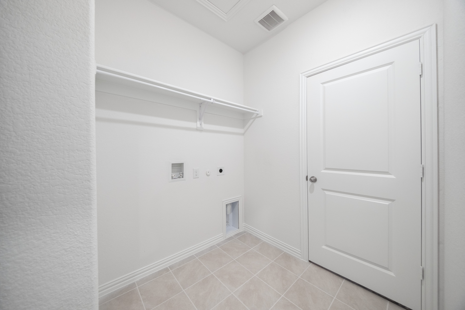 laundry room with tile flooring and storage shelf