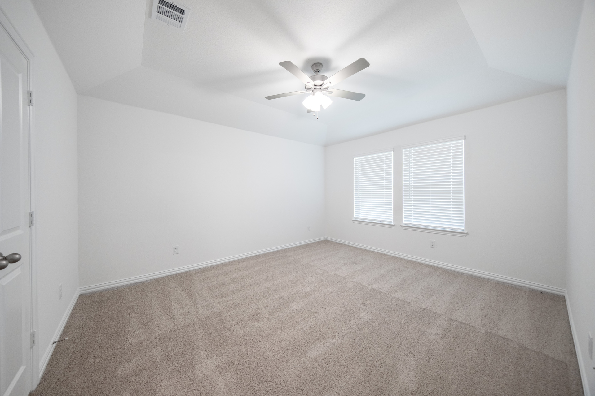 primary bedroom with carpet and windows