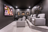 media room in basement with seating and oversized tv