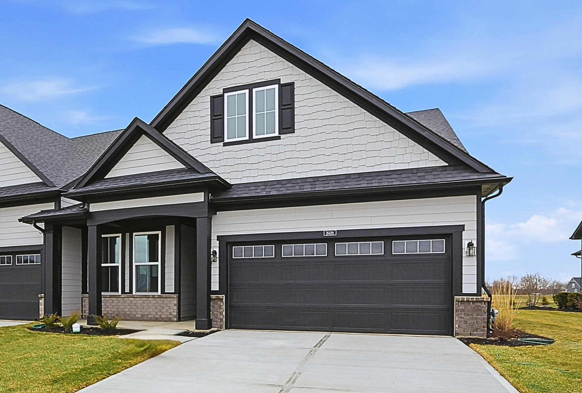 front exterior of home with black garage door and brick detail