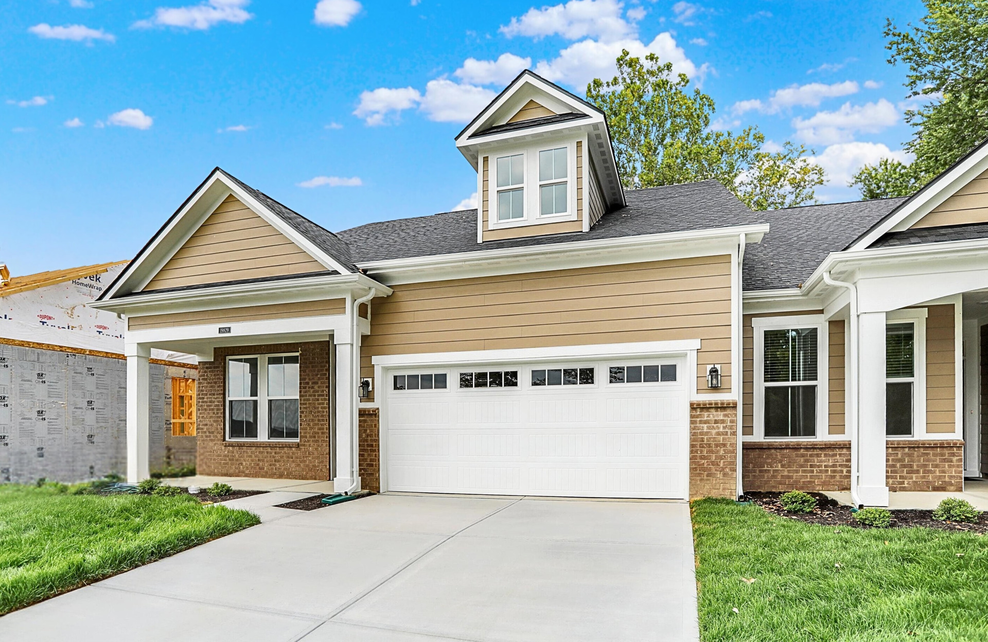 front exterior of home with tan siding and white garage door