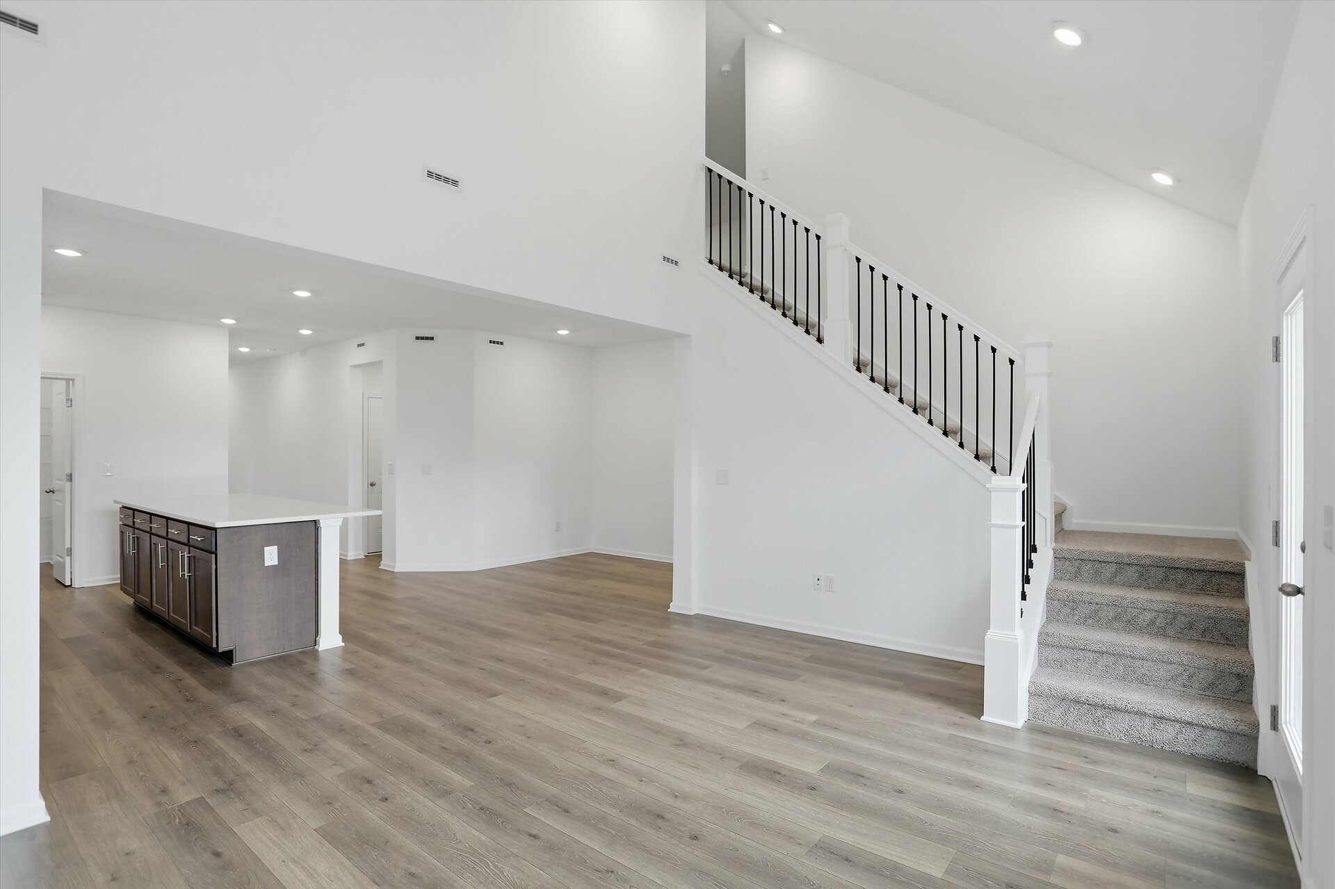 great room with wood plank flooring and two-story great room