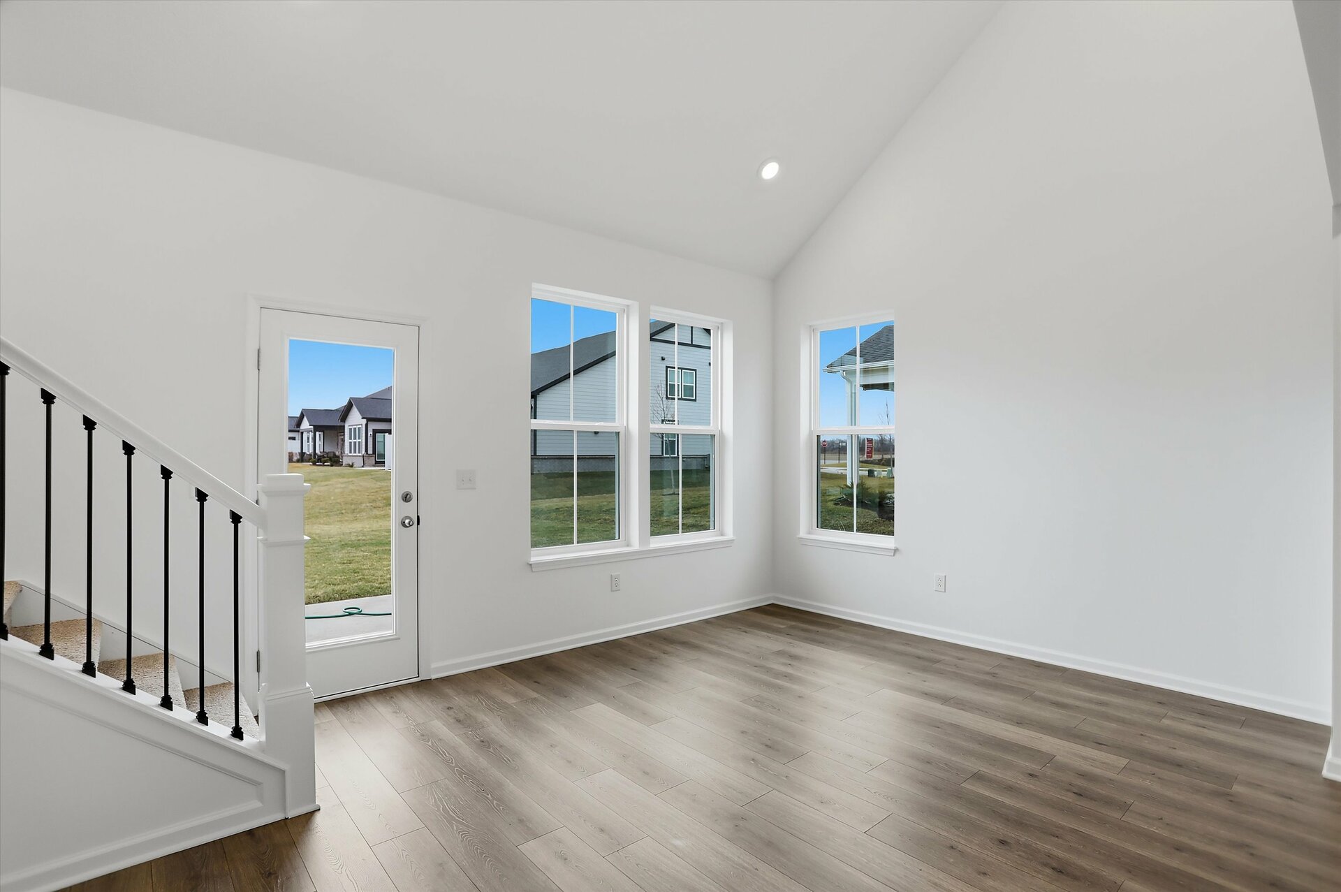 great room with two-story ceilings and a staircase with black metal spindles