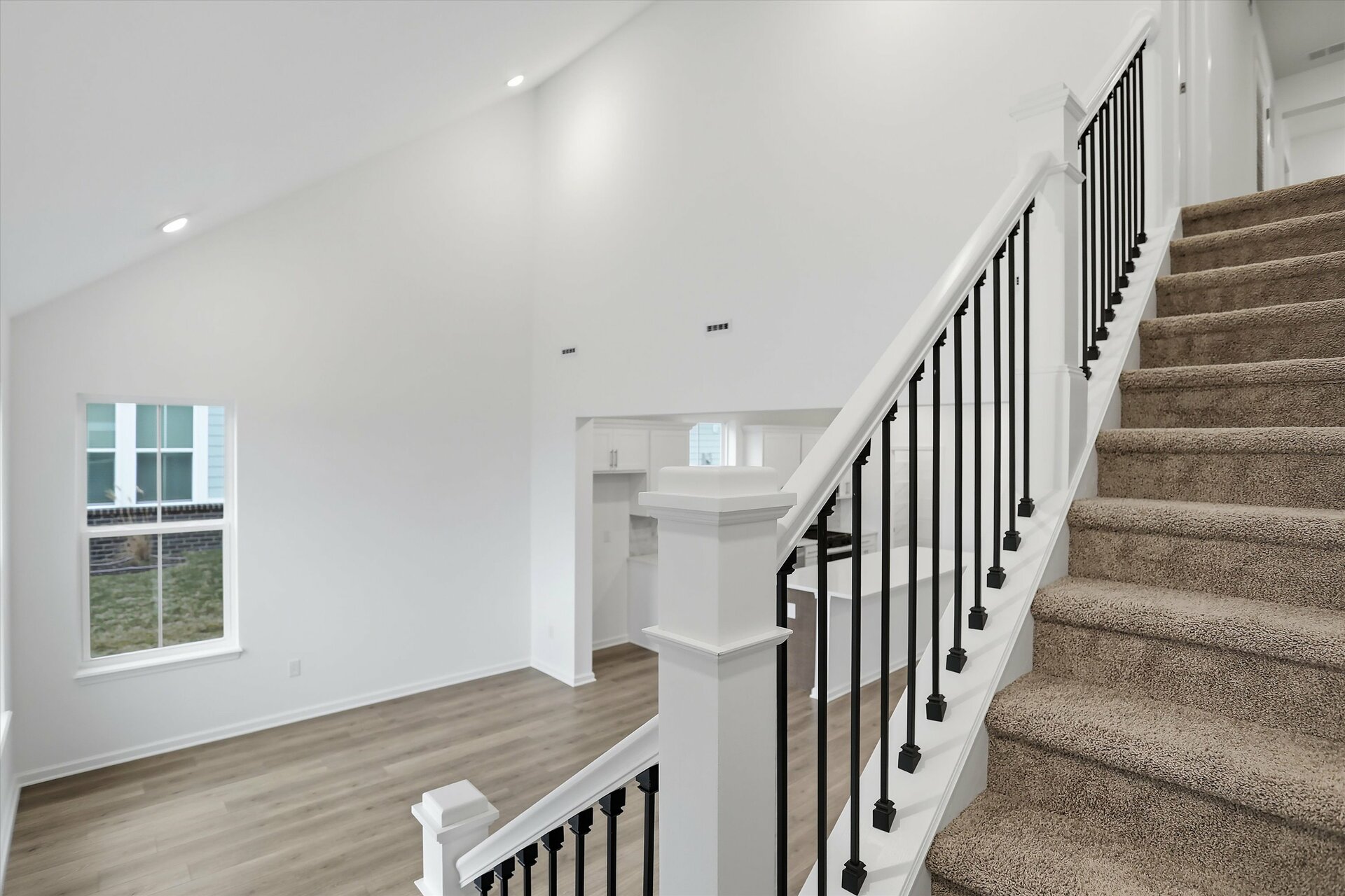 staircase with black metal spindles overlooking the great room