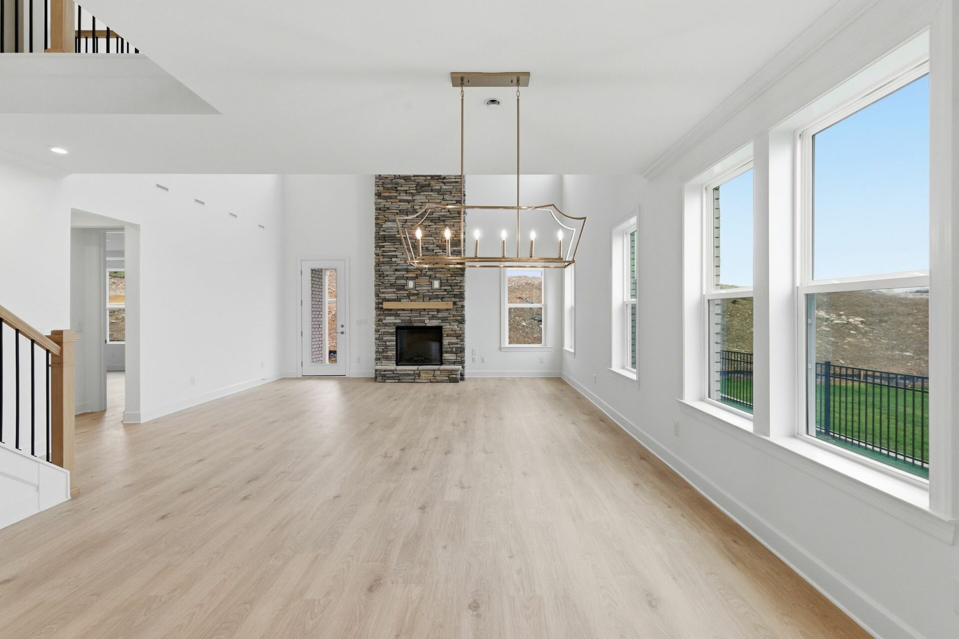 dining room with wood flooring, large light fixture, and a view of the great room